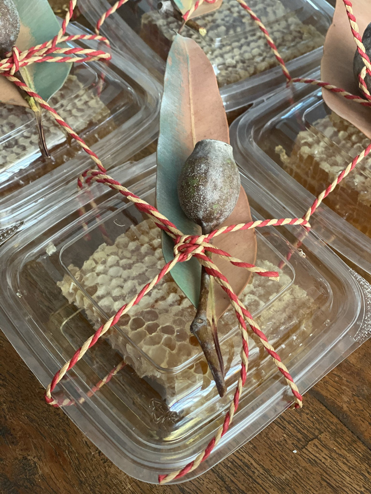Comb honey packs tied with string and a gum leaf