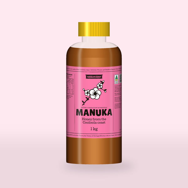 Queensland Manuka Honey in a clear squeeze bottle, the pink manuka label with a flowering tea tree drawn on the front (a render of the new label, coming this season)